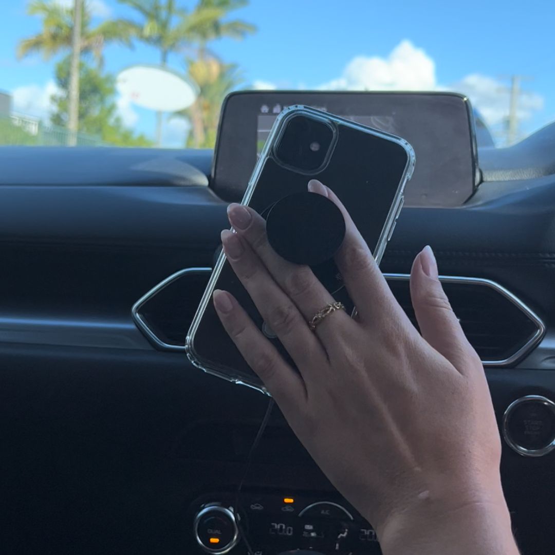 Woman in her car using the Magnetic Phone Grip to hold her phone